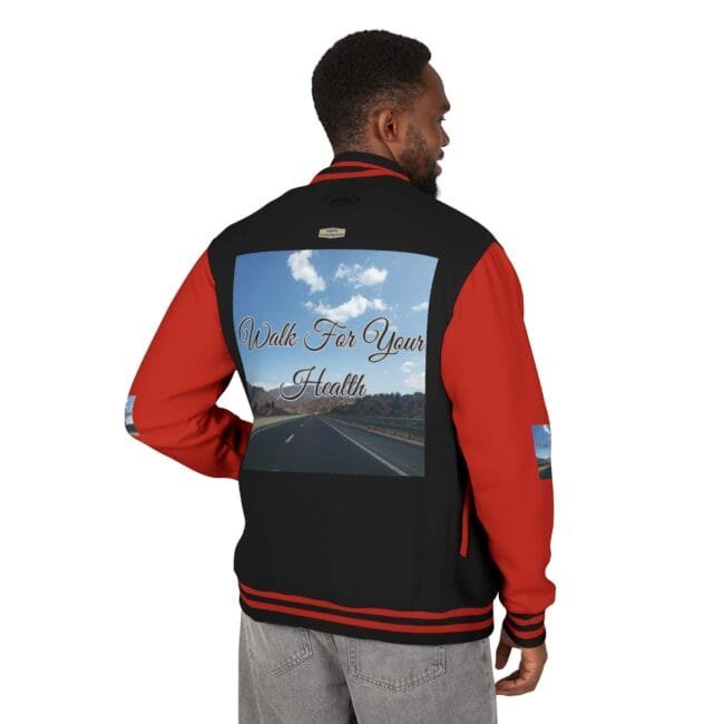 Back view of a man wearing a black and red varsity jacket; the back panel shows a highway under a blue sky with the words 'Walk For Your Health' in cursive.