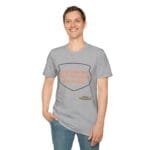Smiling man wearing a gray T-shirt with orange text reading: 'KEEP CALM AND DON’T DISTURB MY HEAD PLEASE!' inside a shield outline on the chest.