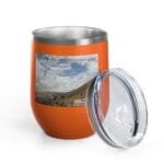 Orange insulated tumbler with a silver rim and a label showing a landscape and the text 'Keep calm and increase your concentration', lid beside it.