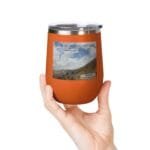 Orange insulated tumbler held in a hand; label features a mountain landscape and the text 'Keep calm and increase your concentration'.