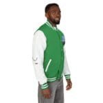 Portrait of a man wearing a green and white varsity jacket with striped cuffs, facing slightly to the right against a white background.