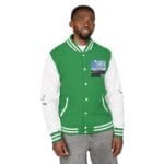 Man modeling a green and white varsity jacket with striped cuffs, chest pocket that has a landscape photo patch, standing and facing camera.
