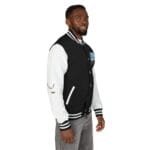 Man wearing a black and white varsity jacket with white sleeves and striped cuffs, facing slightly to the right.