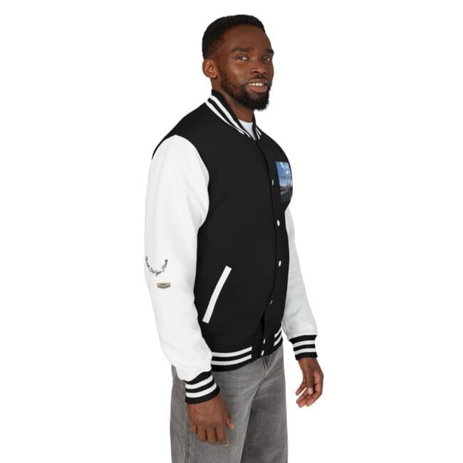 Man wearing a black and white varsity jacket with white sleeves and striped cuffs, facing slightly to the right.
