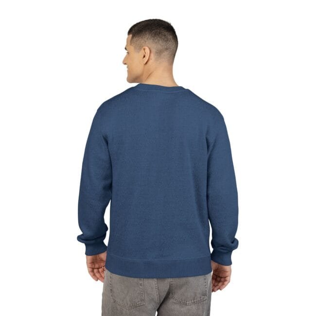 Back view of a man wearing a blue crewneck sweater and gray jeans against a white background.