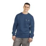 Man in a blue crewneck sweater with a small white embroidered leaf design on the left chest, standing casually and smiling.
