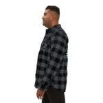Side-profile photo of a man wearing a black-and-dark gray plaid flannel shirt, showcasing its fit and style.