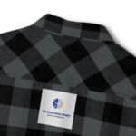 Dark gray and black plaid shirt with a white label pinned on the chest showing a blue/gold brain logo and the text 'The Simple Design Mindset' (tagline: 'Give You A Simple Idea').