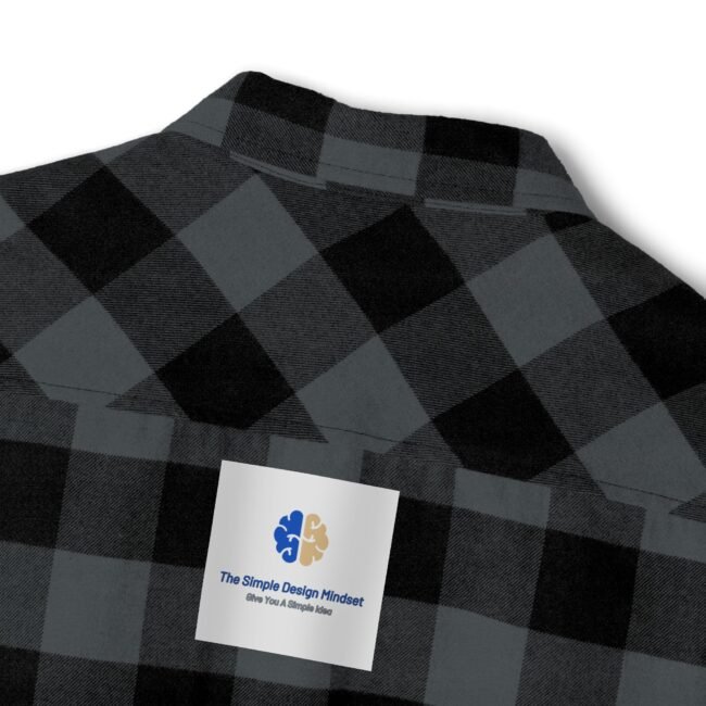 Dark gray and black plaid shirt with a white label pinned on the chest showing a blue/gold brain logo and the text 'The Simple Design Mindset' (tagline: 'Give You A Simple Idea').