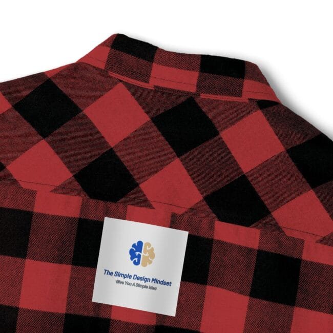 Red and black plaid shirt with a white label patch reading 'The Simple Design Mindset' logo visible on the chest area.