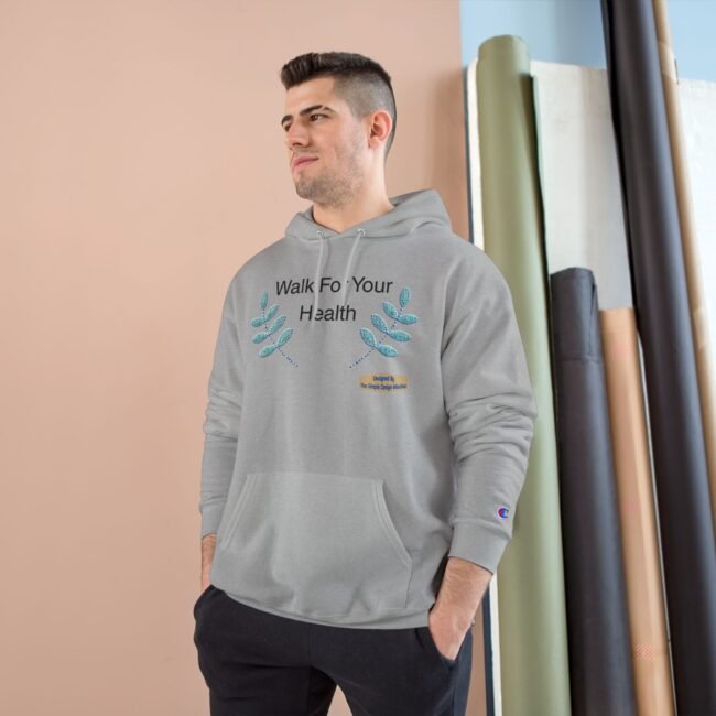 Young man wearing a light gray hoodie with the words 'Walk For Your Health' and teal leaf graphics, posed against a pastel backdrop.