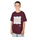 Boy wearing a maroon T-shirt with a light-gray rounded badge on the chest that reads, 'Continuous learning is improving your culture's mindset.'
