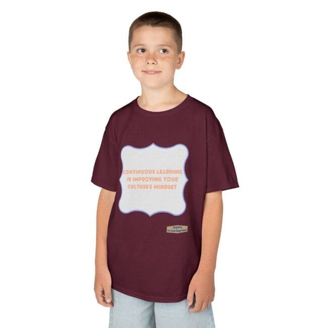 Boy wearing a maroon T-shirt with a light-gray rounded badge on the chest that reads, 'Continuous learning is improving your culture's mindset.'