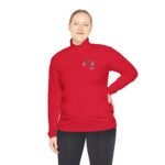 Person in a red long-sleeve pullover with a small left-chest logo, standing with one hand on hip.