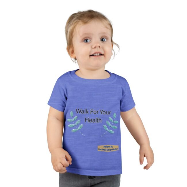 Smiling toddler wearing a blue T-shirt that says 'Walk For Your Health' with leafy designs on the sides.