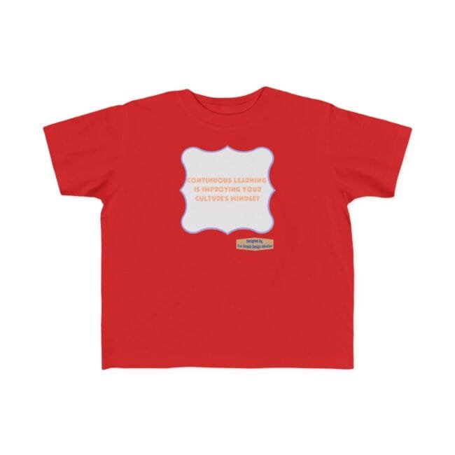 Red children's T-shirt with a white decorative frame in the center bearing orange slogan about continuous learning; a small yellow label below reads 'Designed by The Simple Design Mindset'.