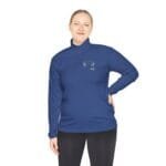 Woman wearing a blue quarter-zip pullover with a small embroidered logo on the left chest, standing against a white background.