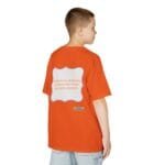 Back view of a boy in an orange T-shirt; a large white framed graphic on the back contains the text: 'Continuous learning is improving your culture's mindset'.
