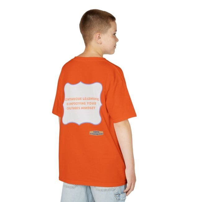 Back view of a boy in an orange T-shirt; a large white framed graphic on the back contains the text: 'Continuous learning is improving your culture's mindset'.