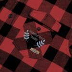 Red and black plaid flannel shirt pocket with embroidered 'Walk For Your Health' slogan and blue leaf accents.