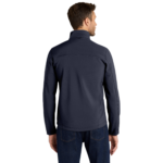 Man standing with his back to the camera, wearing a dark navy jacket and jeans
