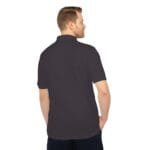 Back view of a man wearing a dark polo shirt with his hands in his pockets.