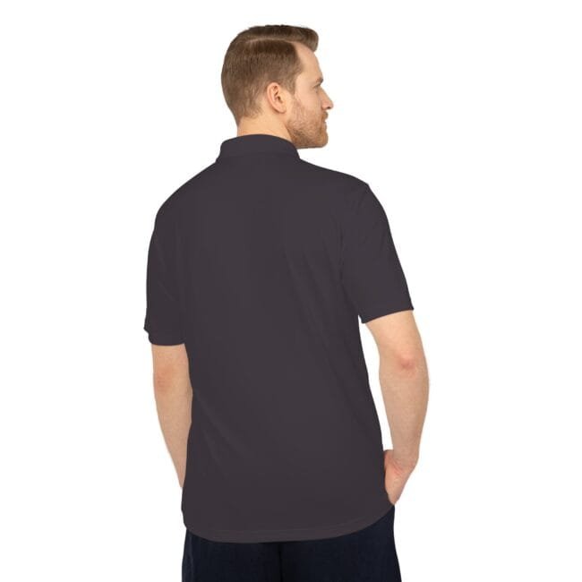 Back view of a man wearing a dark polo shirt with his hands in his pockets.