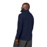 Back view of a man in a navy athletic jacket with a high collar and a logo on the left sleeve.