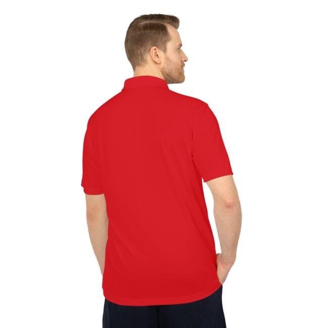 Back view of a man wearing a red polo shirt, with hands in pockets.