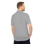 Back view of a man wearing a light gray polo shirt with short sleeves, hands in pockets against a white background.