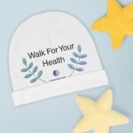 Close-up of a white circular banner that reads 'Walk For Your Health' with blue leaf graphics on a pale blue background; a yellow knitted star is in the corner.