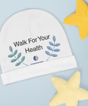 Close-up of a white circular banner that reads 'Walk For Your Health' with blue leaf graphics on a pale blue background; a yellow knitted star is in the corner.