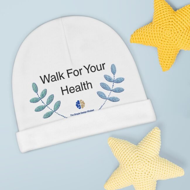 Close-up of a white circular banner that reads 'Walk For Your Health' with blue leaf graphics on a pale blue background; a yellow knitted star is in the corner.