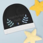Black circular fabric with blue embroidered leaves and the phrase 'Walk For Your Health' on a pale blue background, with a yellow knitted star in the top-right corner.