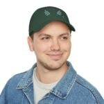 Man wearing a dark green cap with 'Walk For Your Health' and blue leaf graphics, smiling slightly, denim jacket visible.