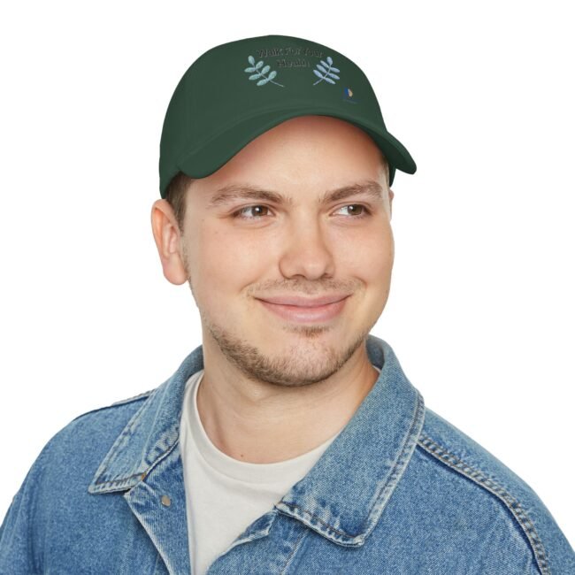 Man wearing a dark green cap with 'Walk For Your Health' and blue leaf graphics, smiling slightly, denim jacket visible.