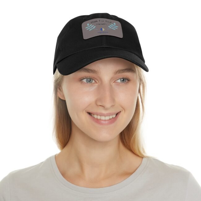 Close-up of a person wearing a black cap with a gray patch that reads 'Walk For Your Health' and decorative blue leaves on the patch.