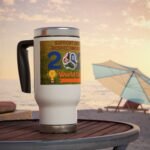 Close-up of a white travel mug on a wooden table at the beach, with a colorful World Cup sticker on its side and a sunset sky behind.