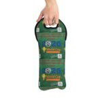 Hand gripping a circular promotional bag with a green grass design reading 'World Cup 2026' and supporting text logos.