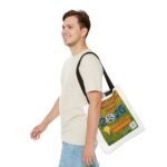 Side view of a smiling man wearing a light-colored T-shirt and jeans, carrying a white tote bag with a large colorful poster tucked under his arm