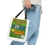 Person in blue jeans holds a white tote bag with a green poster urging support for the team and mutual respect, featuring a soccer ball graphic.