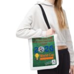 Person wearing a white hoodie with a green banner-style poster hanging from the shoulder that reads 'Support our team by respecting each other'.