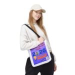 Young woman wearing a white hoodie and cap, holding a purple race bib across her torso.
