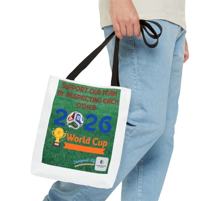 Person in jeans holding a white tote bag with a bold poster reading, “Support our team by respecting each other,” over a green field design.