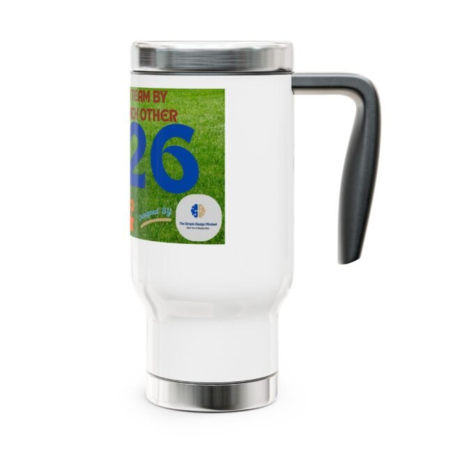 Close-up of a white mug with a colorful label showing a green grass background and large blue number 26, with a dark handle on the right.