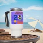 White travel mug with a purple World Cup sticker and soccer ball graphic on a wooden table at the beach